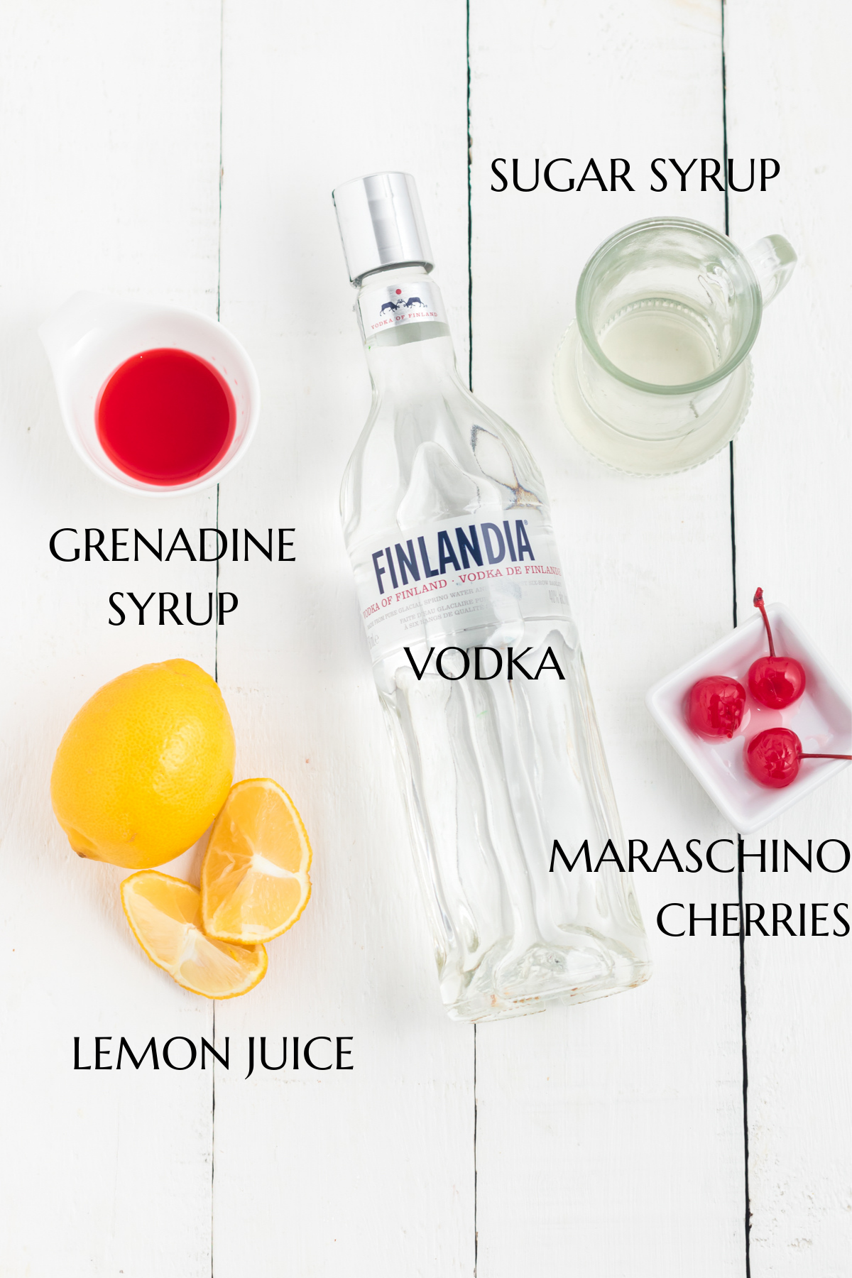 Vodka, grenadine, lemons, sugar syrup and cherries on white table.