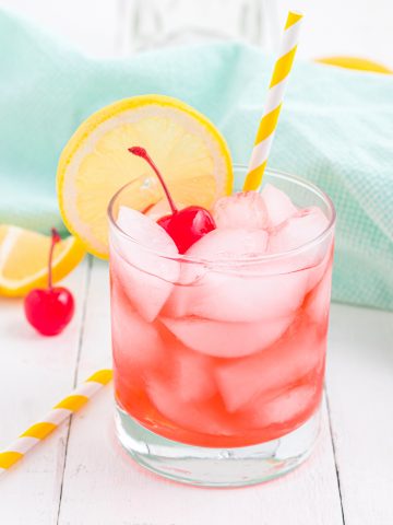 Cherry Vodka sour with a yellow straw and maraschino cherry and lemon slice for garnish