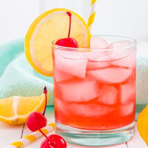 cherry cocktail with lemon and cherries on the table