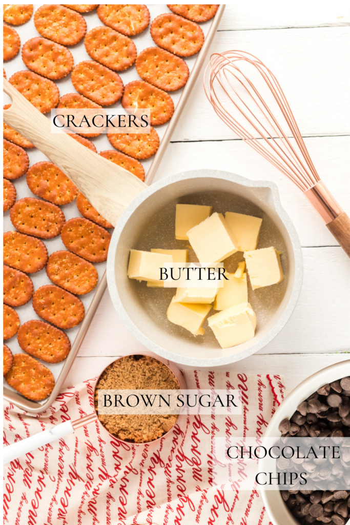 Ingredients to make a christmas crack recipe. crackers, butter, brown sugar and chocolate chips on  a white table with a whisk.