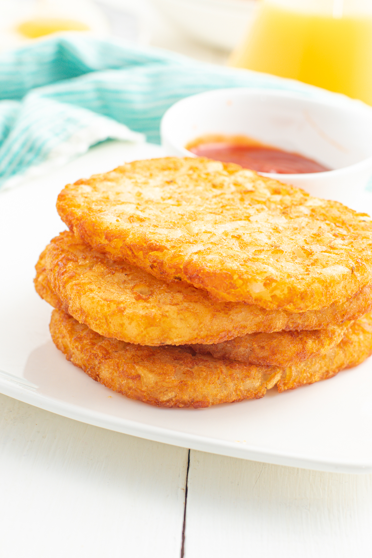 air fryer hash browns stacked on a plate