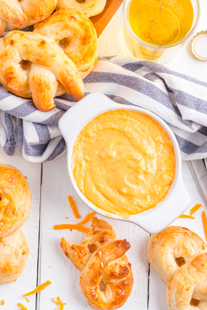 Pretzel beer cheese dip on table with soft pretzels.