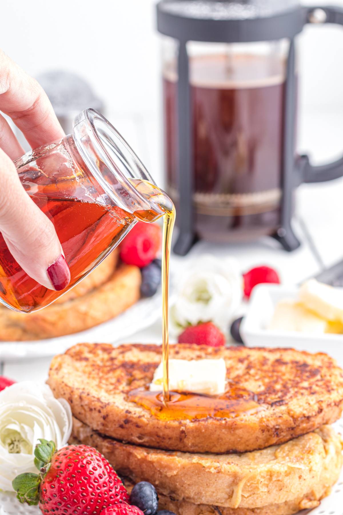 Maple syrup being poured onto French toast.