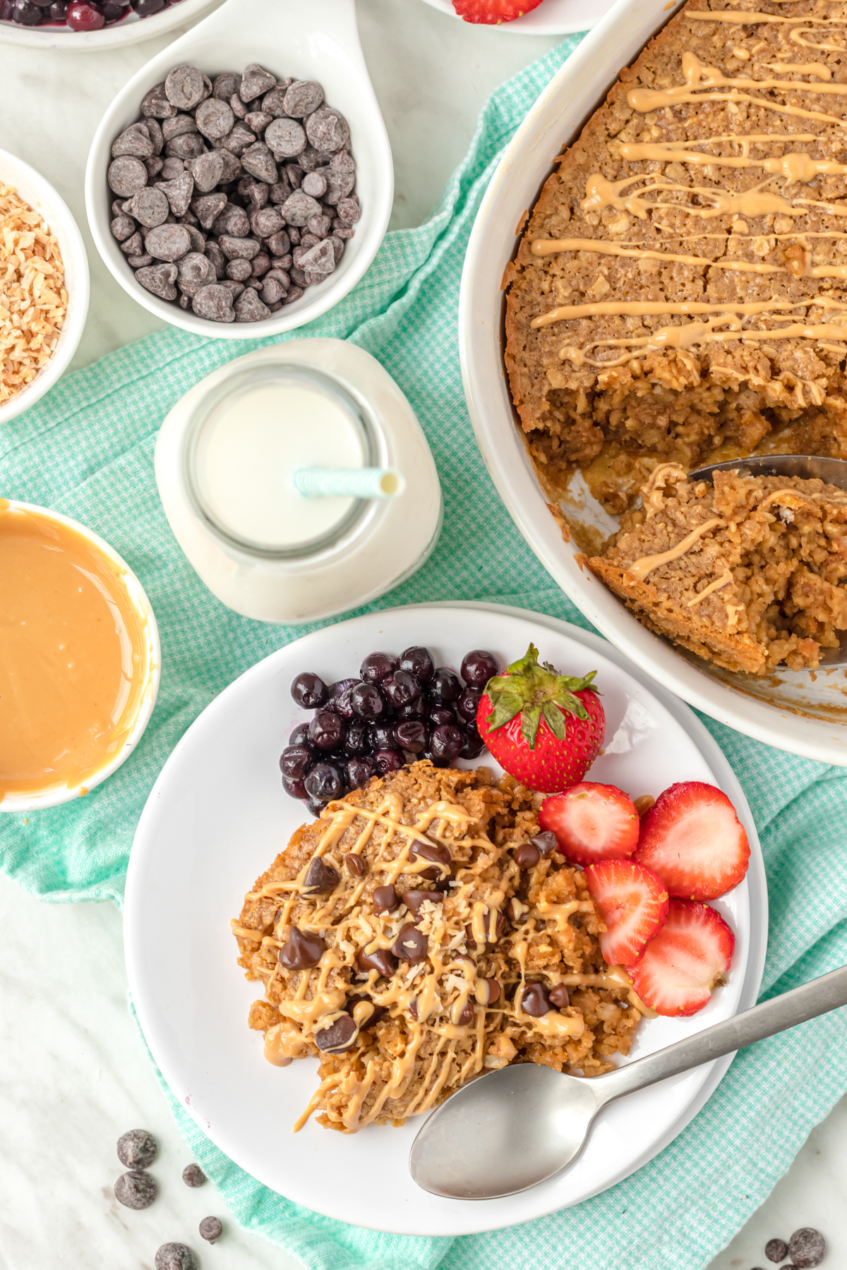 Healthy baked peanut butter oatmeal with healthy toppings on table.