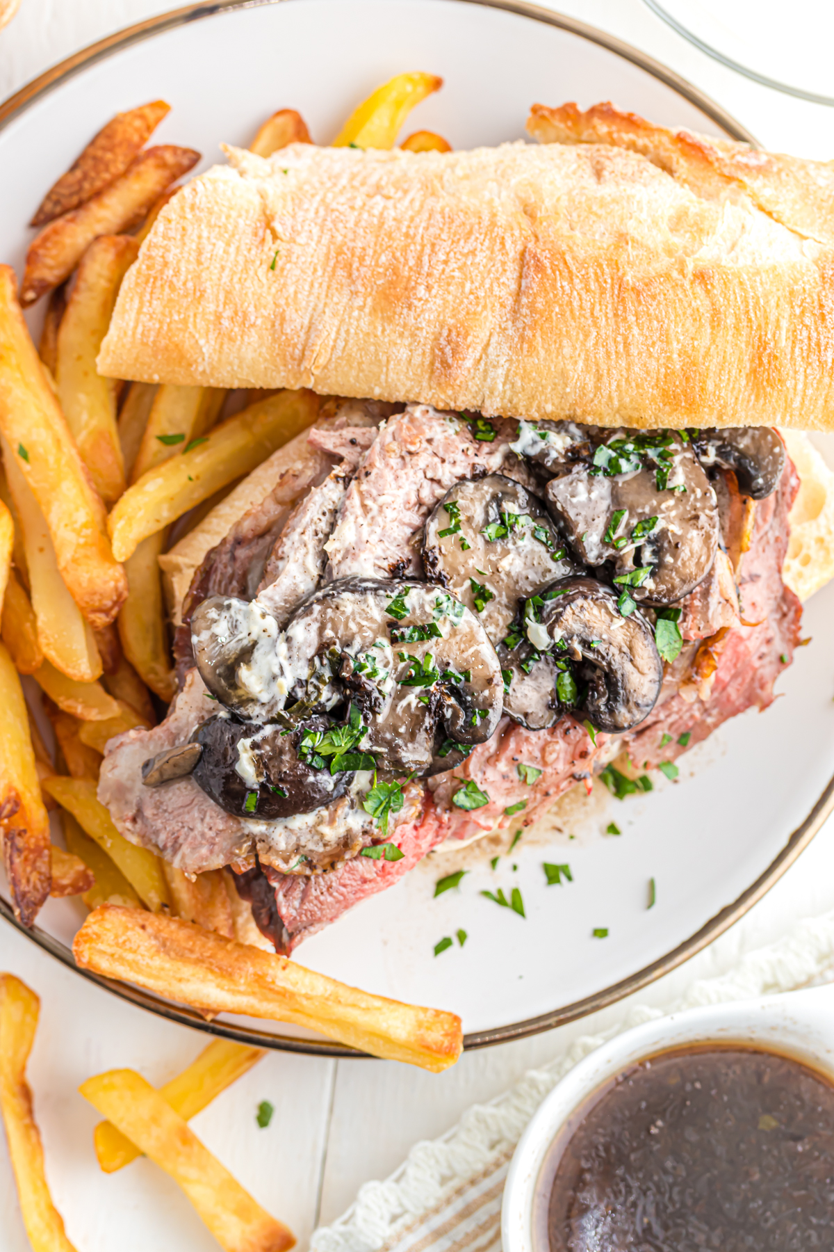 Open-faced leftover prime rib sandwich on a plate with fries.