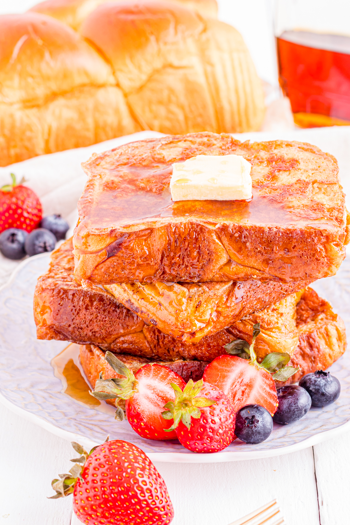 Brioche french toast on plate with berries.