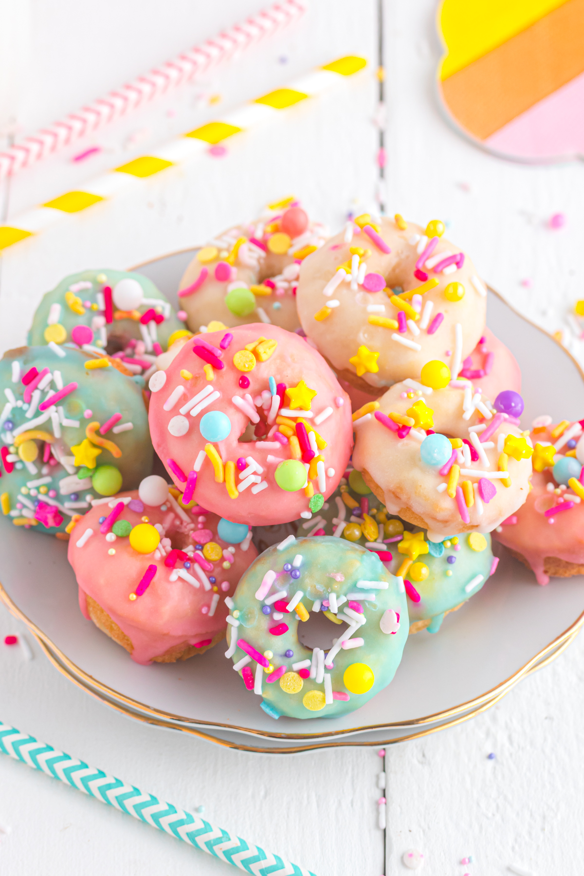 Mini donuts with colorful sprinkles on a plate.
