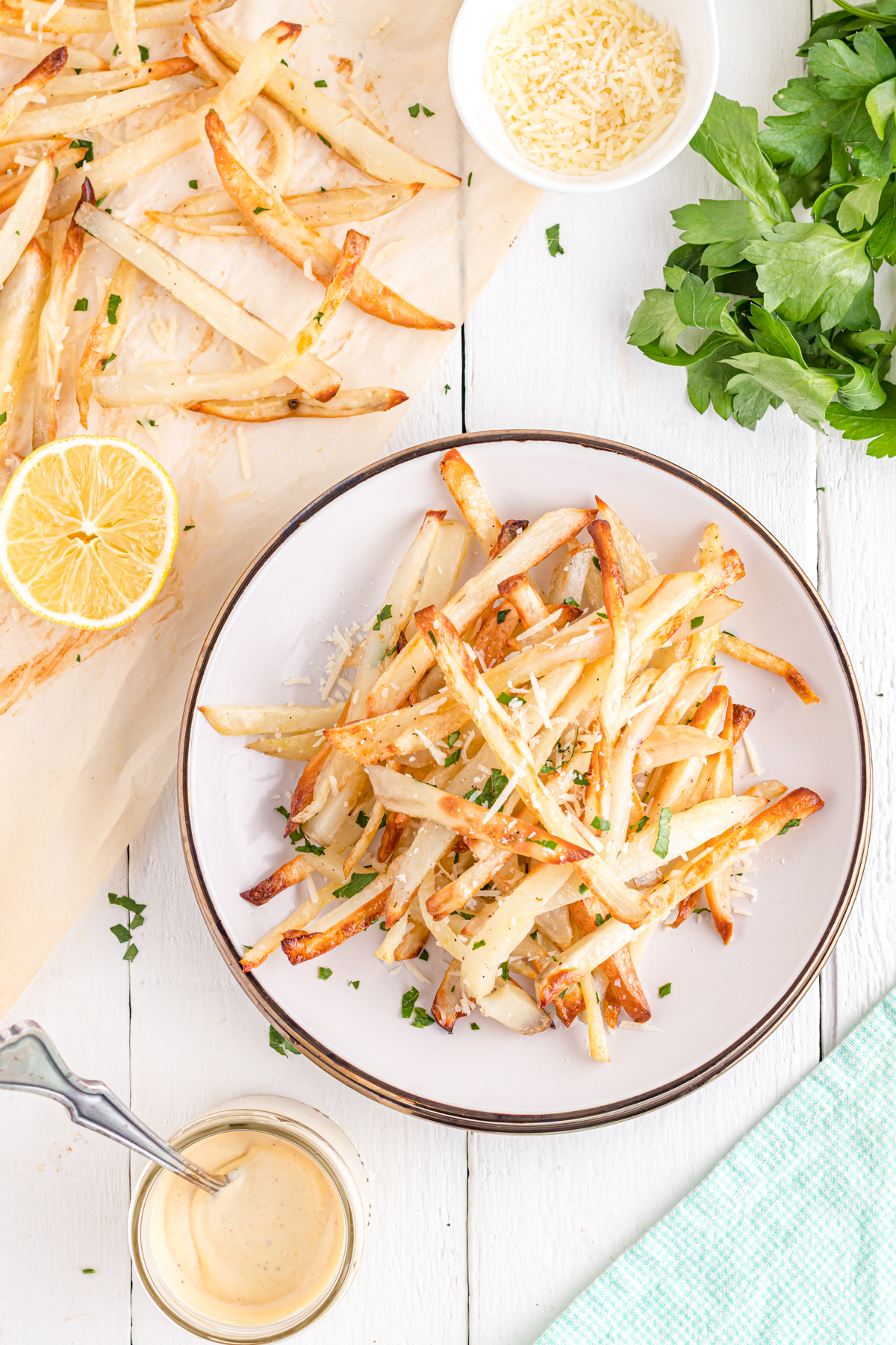 Fries on table with aioli and parsley.