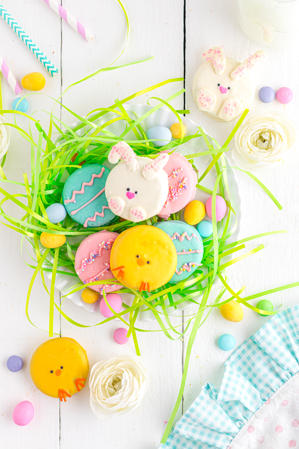 Easter decorated Oreos on a plate with Easter grass.