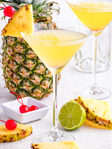 Martini with Pineapple on table with garnishes.