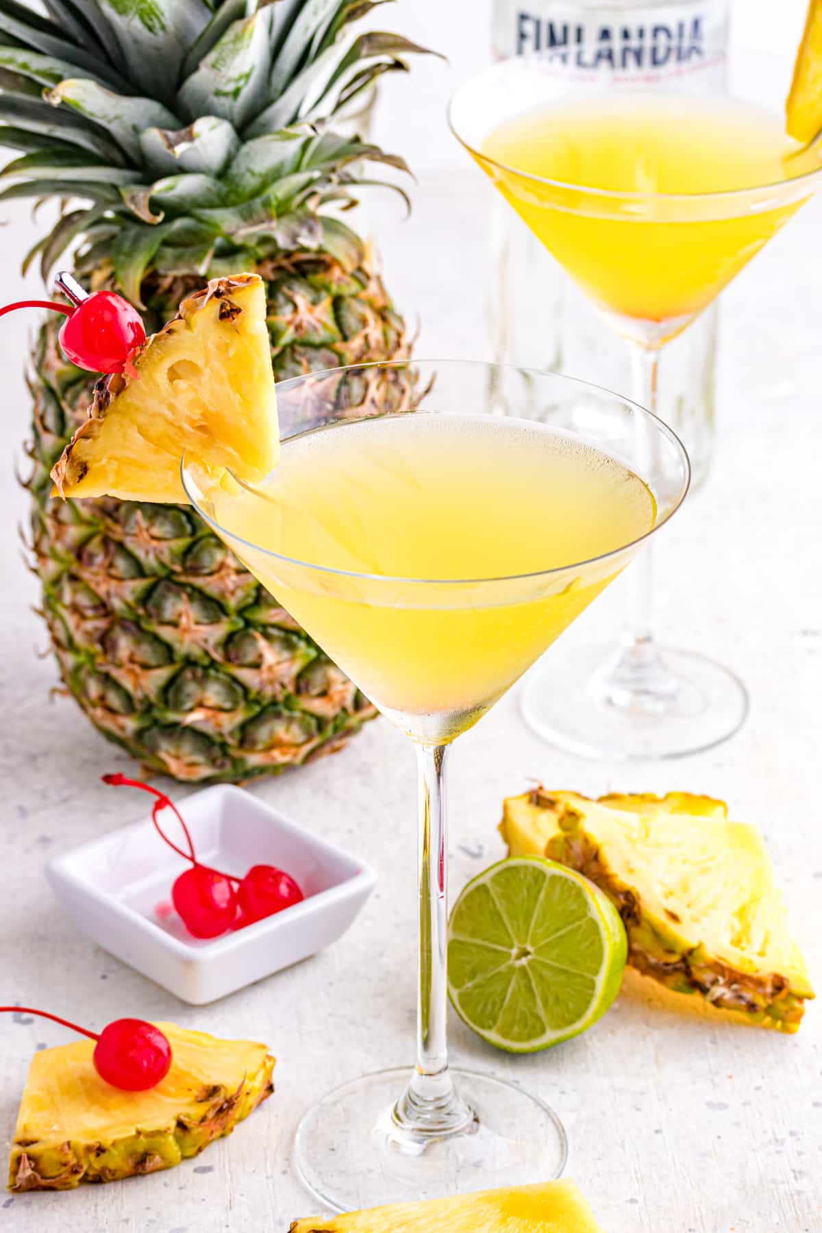 Pineapple martini on table with garnishes.