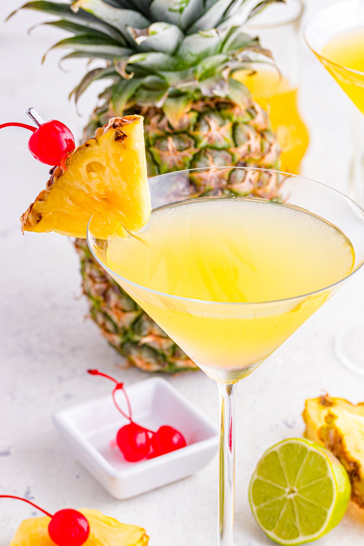 Pineapple cocktail with pineapple wedge and cherry garnish.