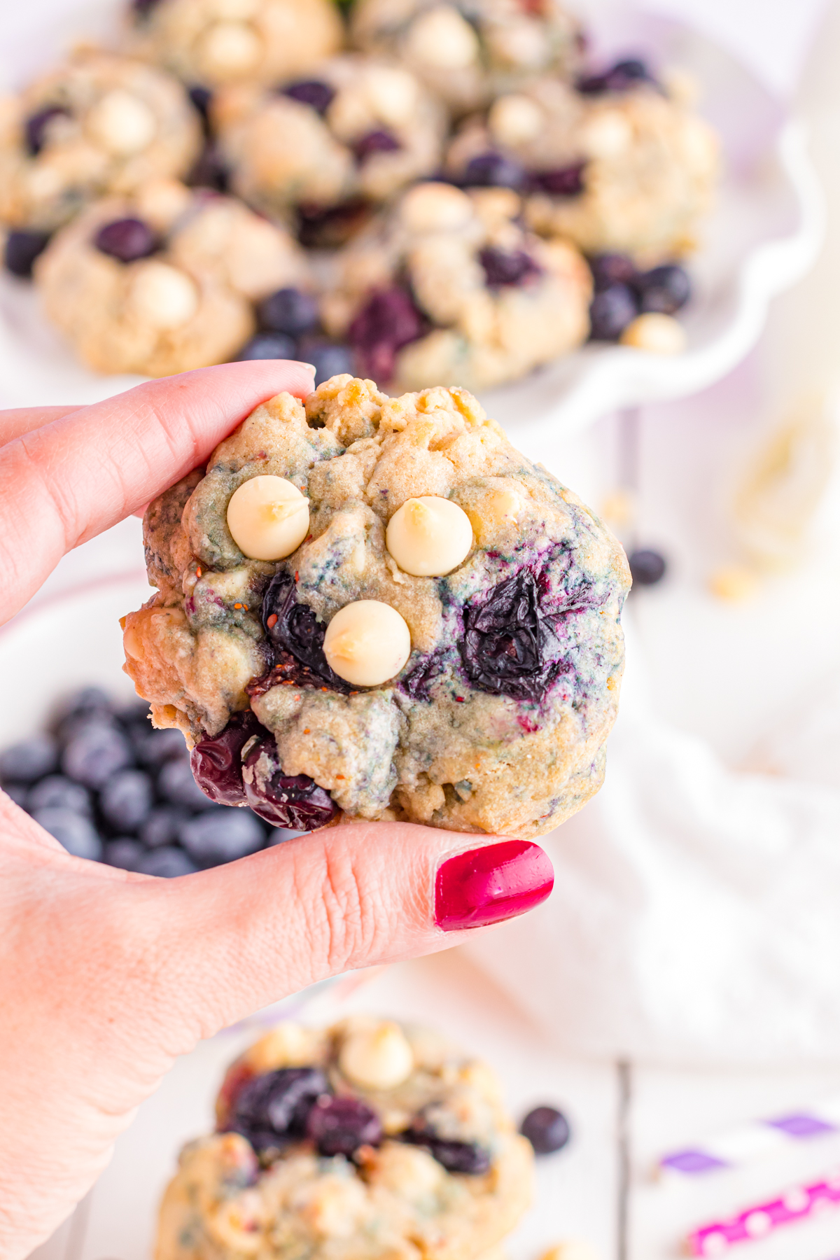 Hand holding a blueberry cookie.