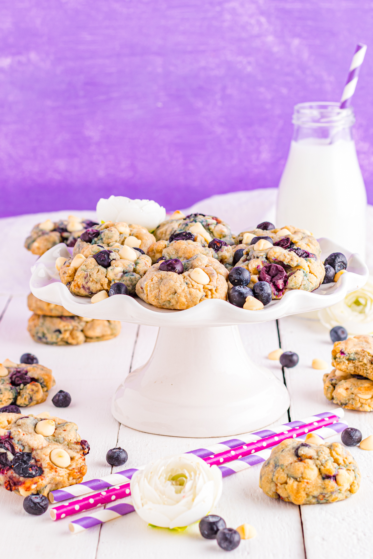 Blueberry cookies on table with milk and blueberries.