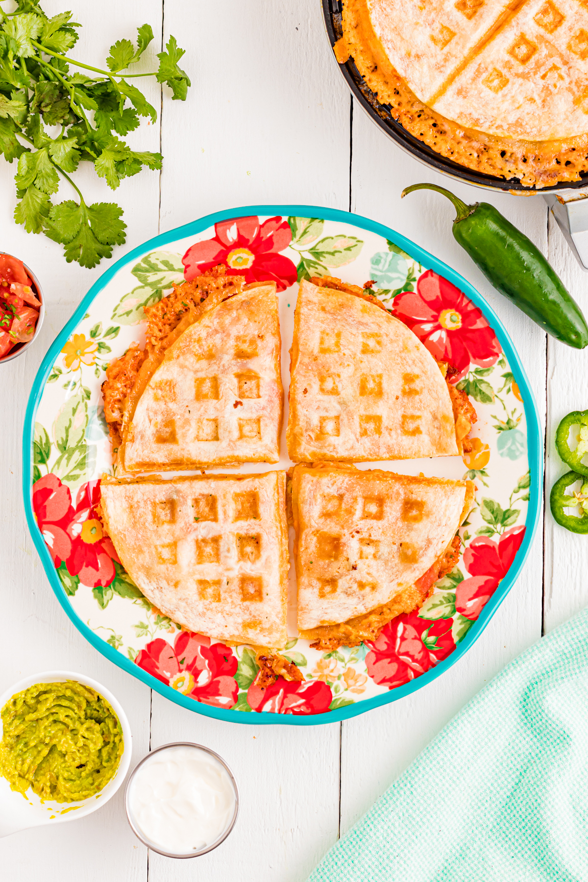 A cooked quesadilla in a waffle maker on a plate.