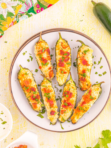 Air fryer jalapeno poppers on yellow table.