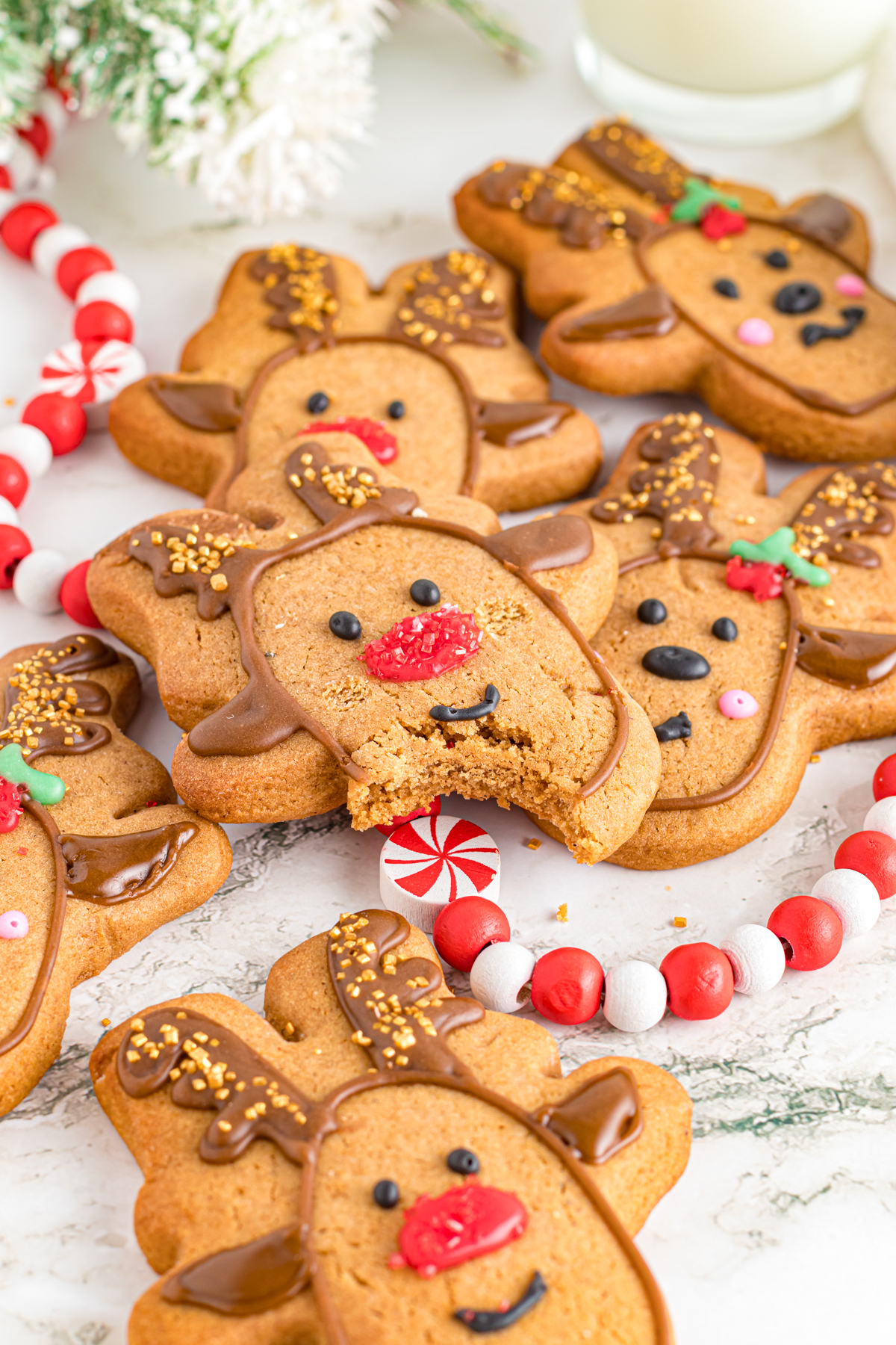 Reindeer cookies on table. one has a bite out.