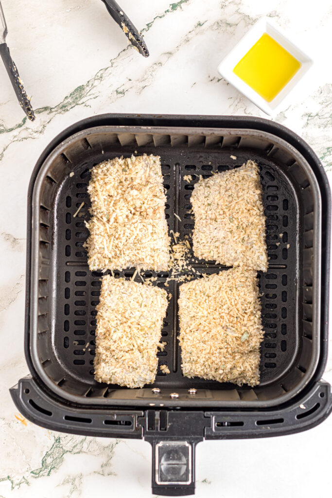 Crusted fish placed in air fryer basket.