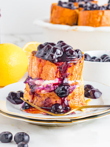 Stuffed blueberry French toast on plate with gold fork.
