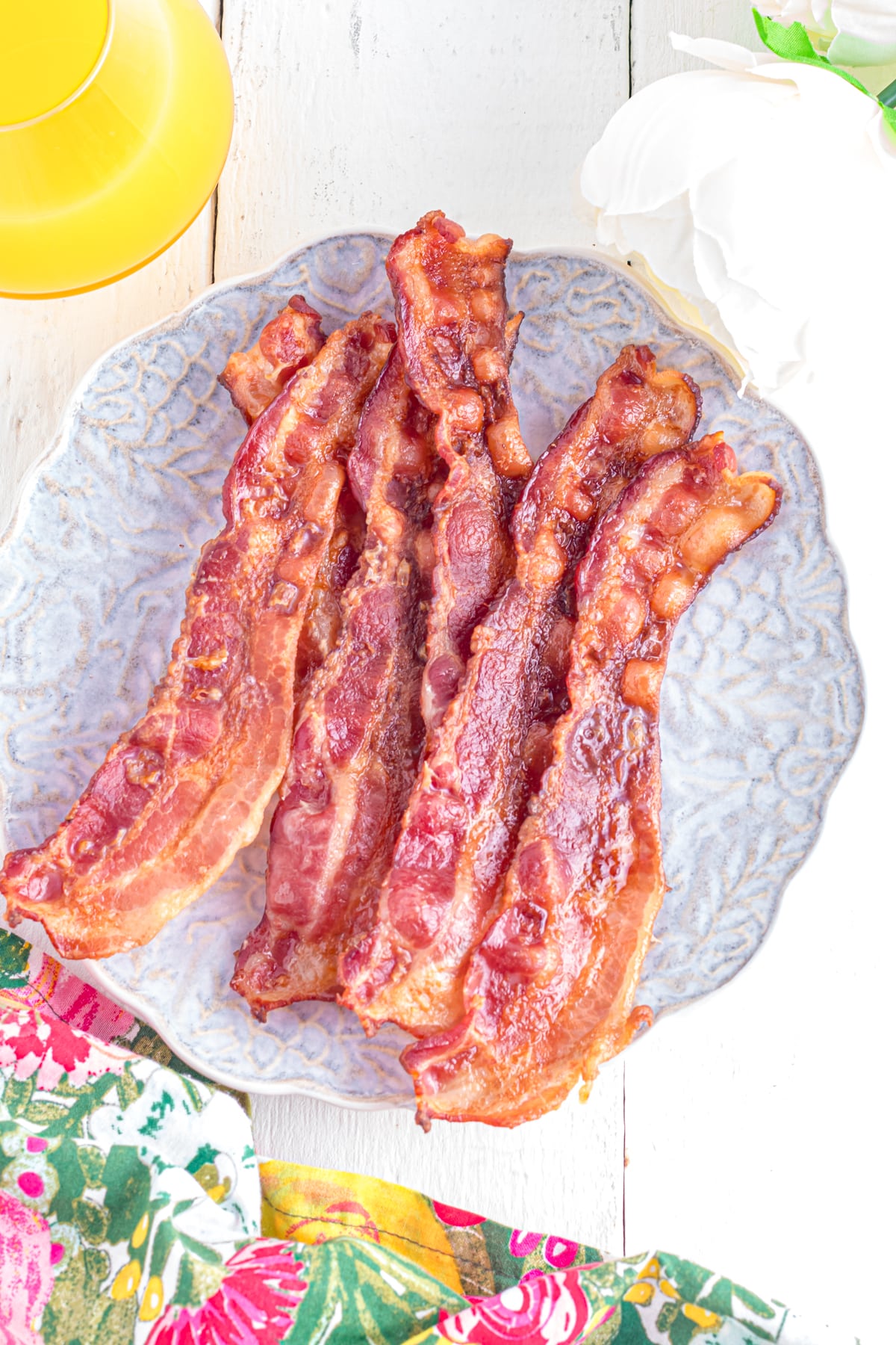 Toaster oven bacon on a plate on the table with a floral linen.