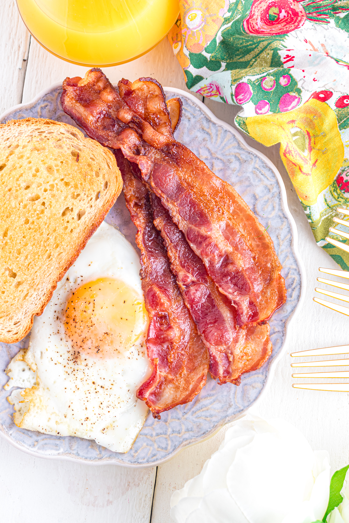Bacon eggs and toast on plate.