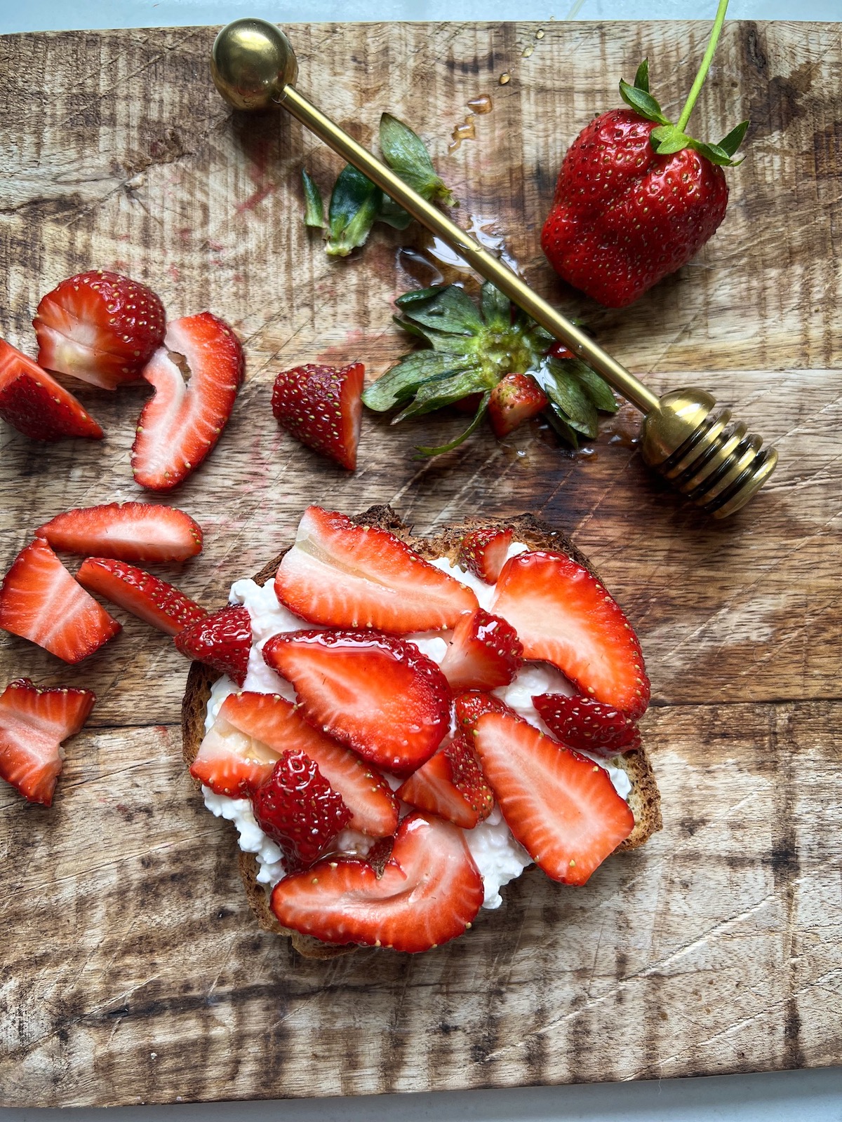 Strawberry ricotta toast on wood table.