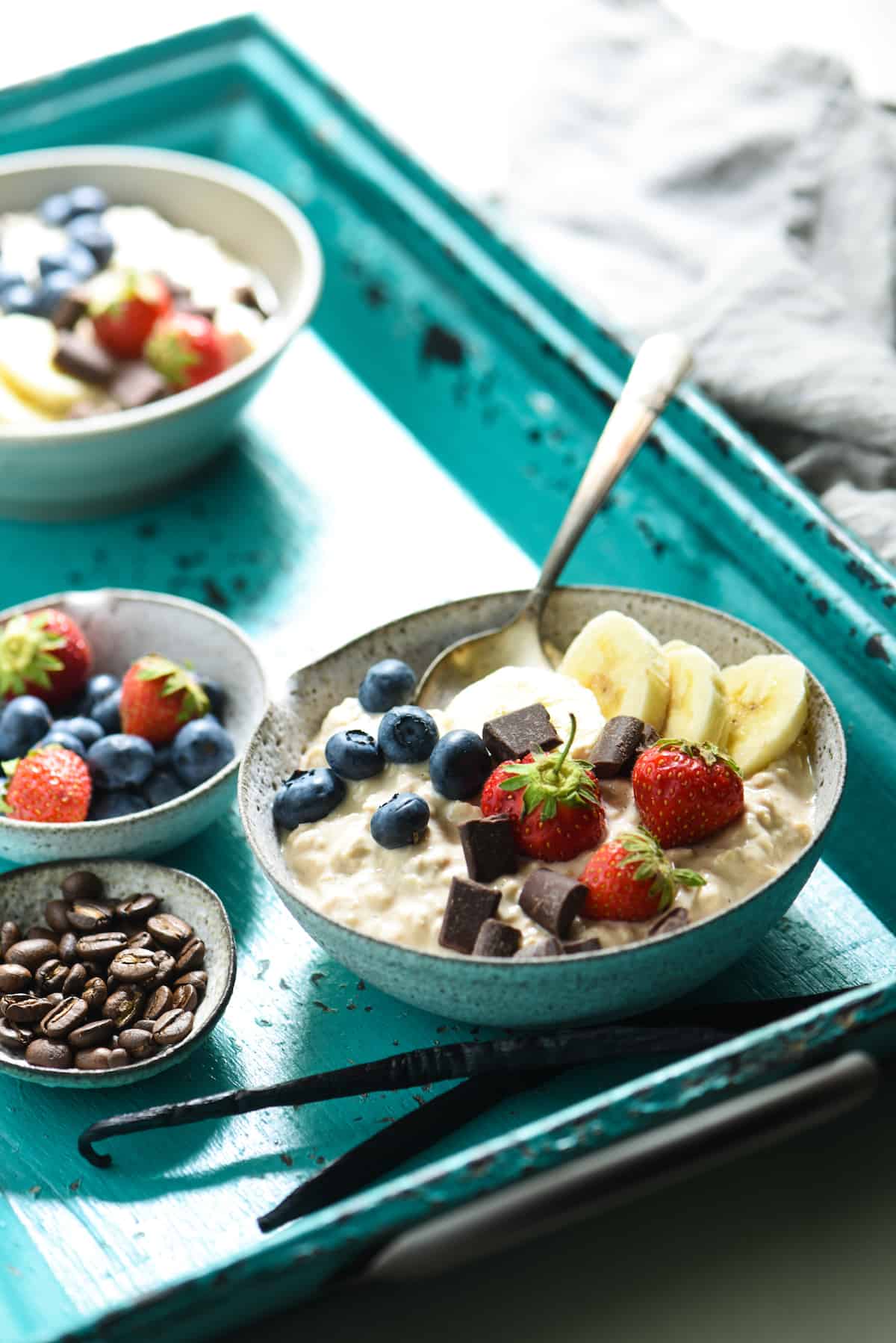 Vanilla overnight oats in bowl with berries and chocolate.