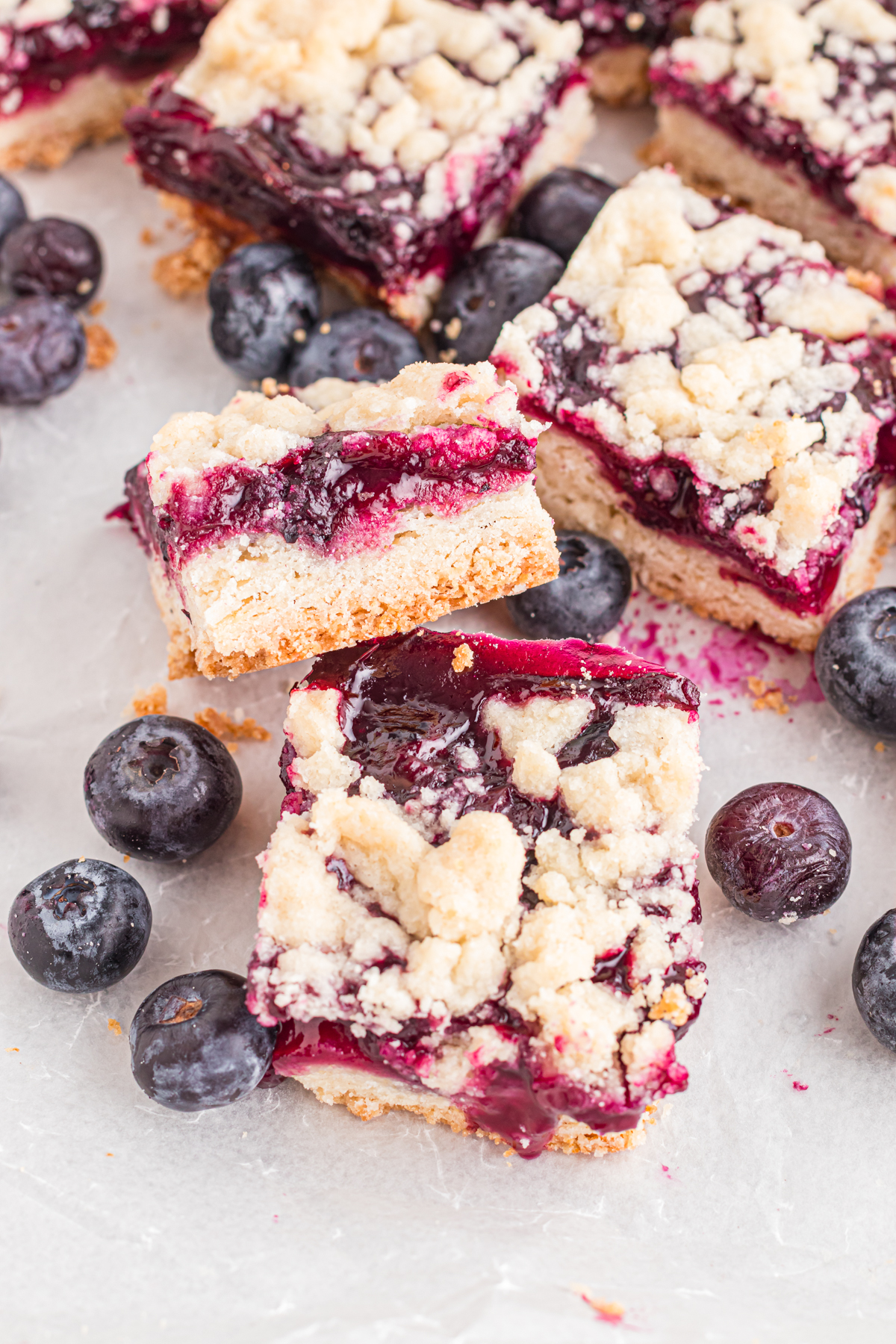 Blueberry bars on table with blueberries.