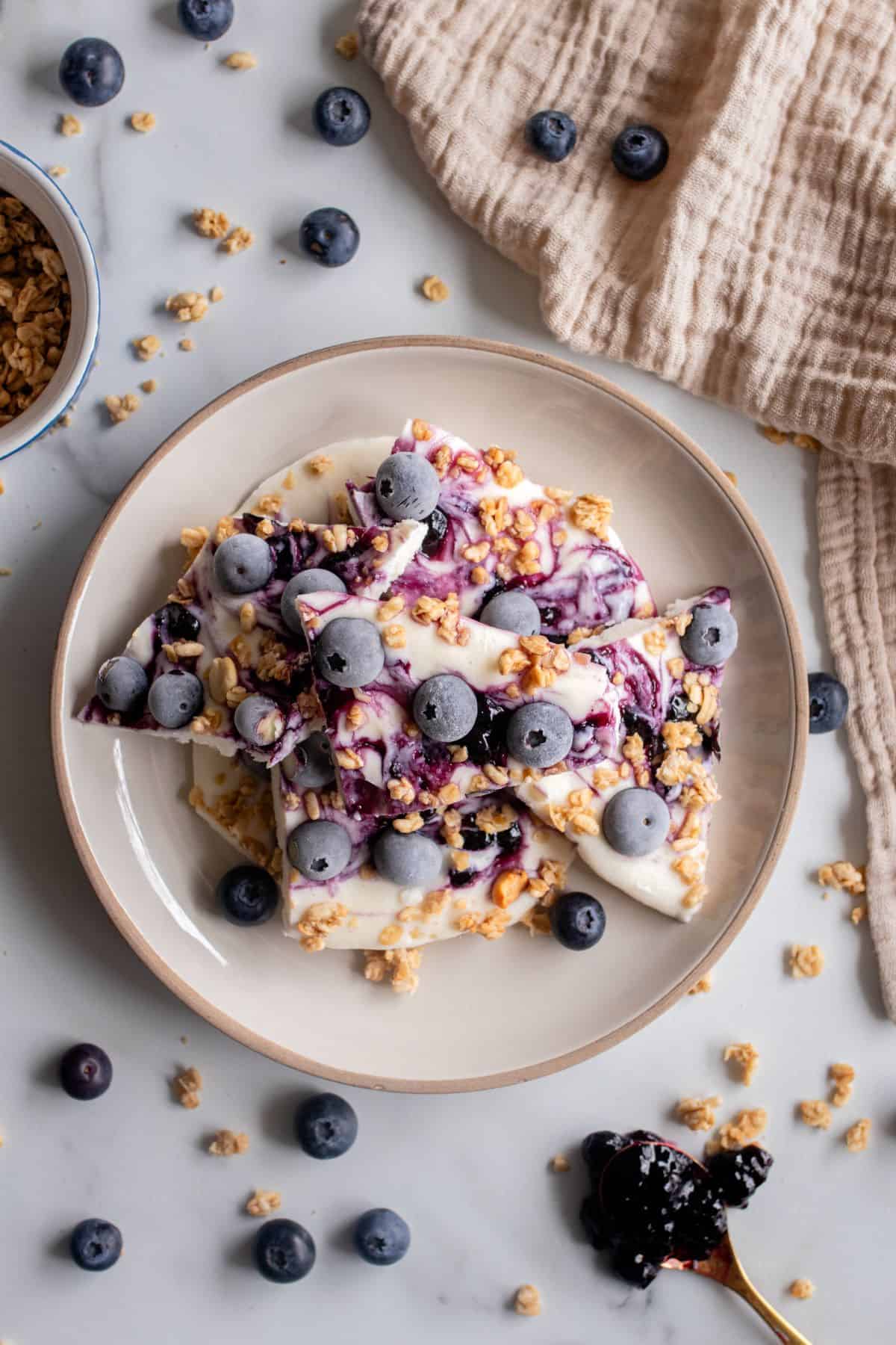 Blueberry cottage cheese bark on table with blueberries.