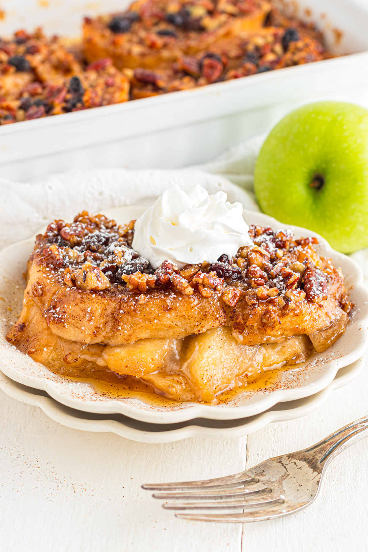 Apple French Toast Casserole on a plate topped with whipped cream.