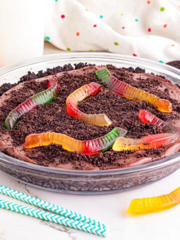 Dirt pie in a glass pie plate topped with gummy worms.