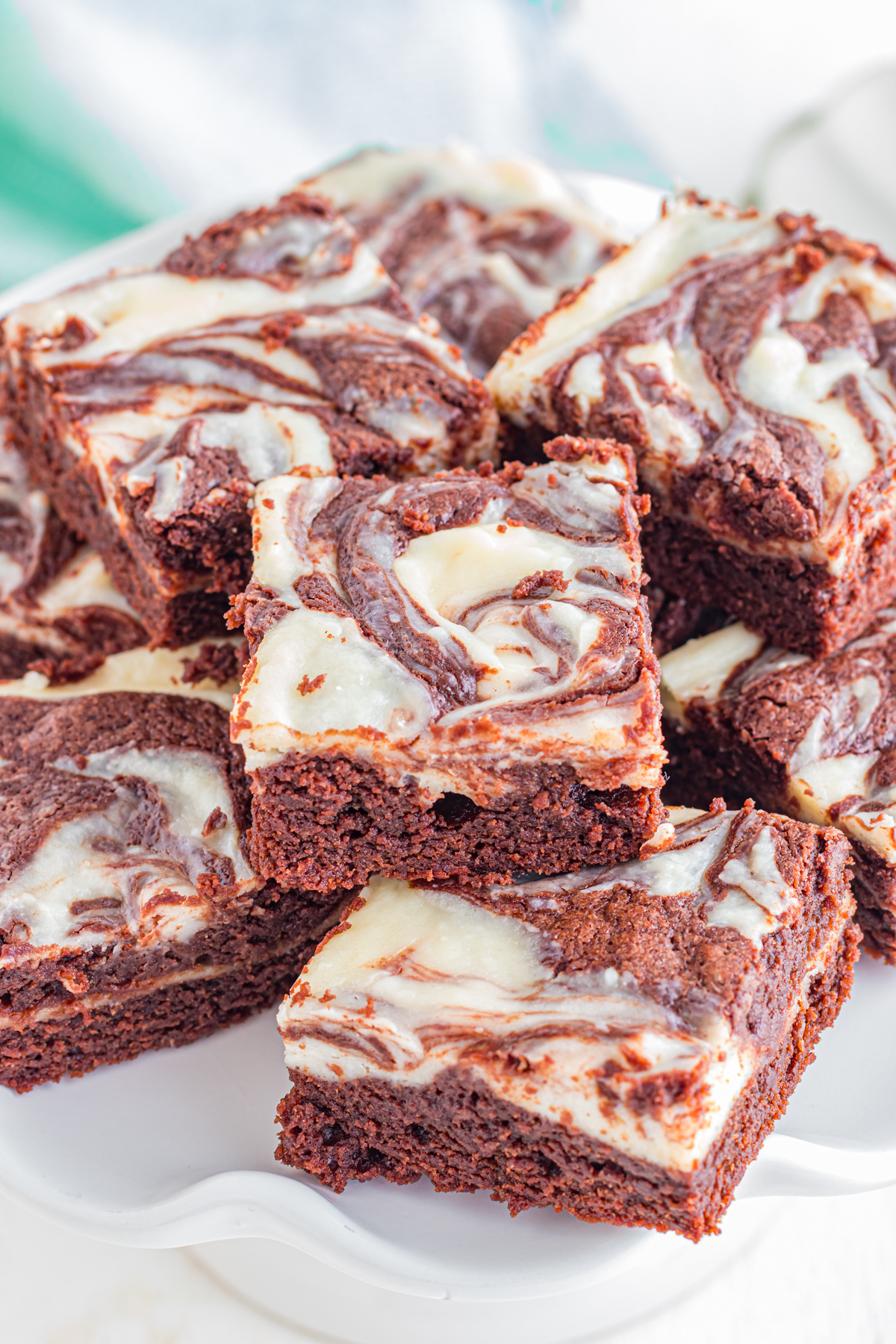 Cream cheese brownies stacked on top of each other.