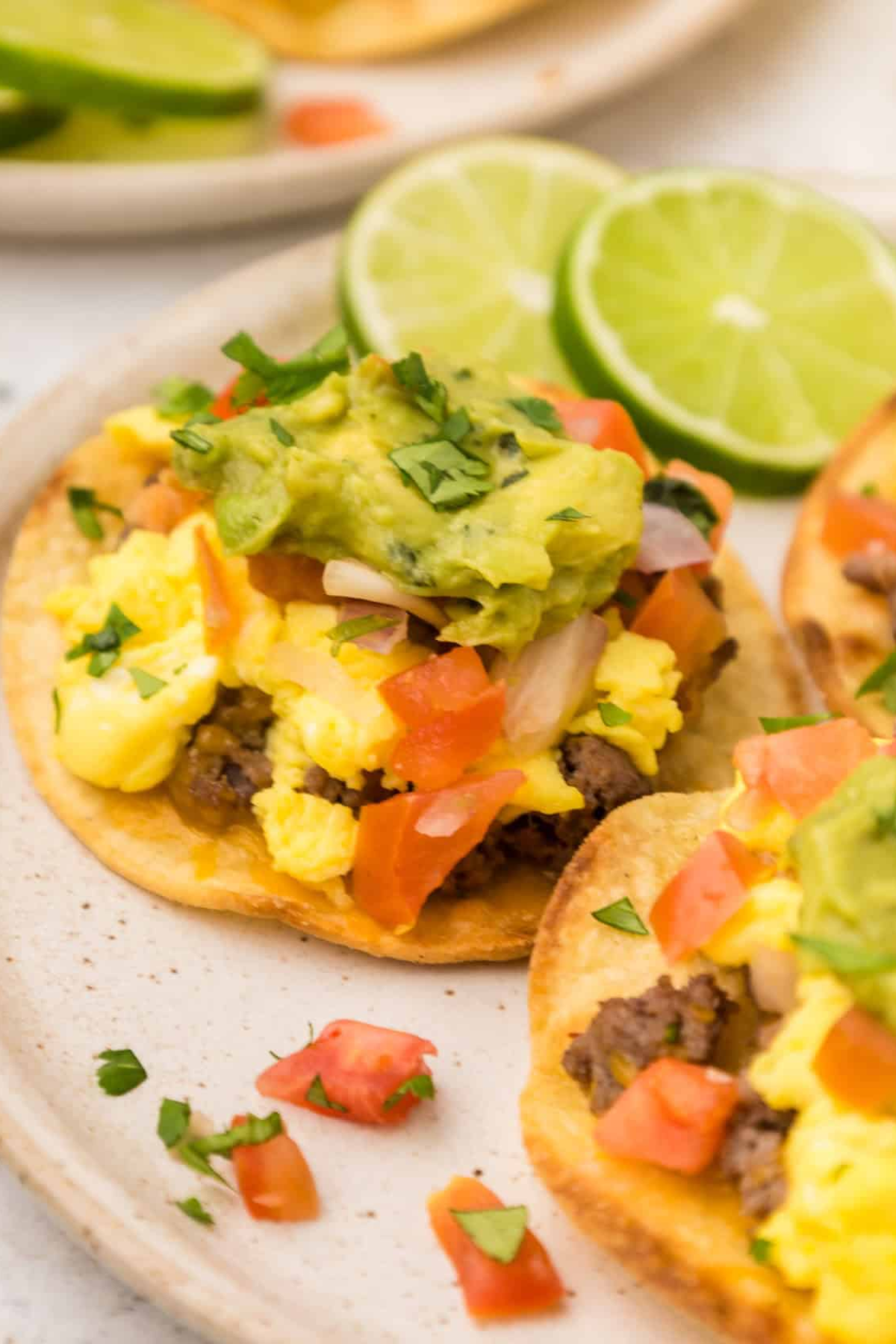 Breakfast Tostadas with lime slices on a plate.