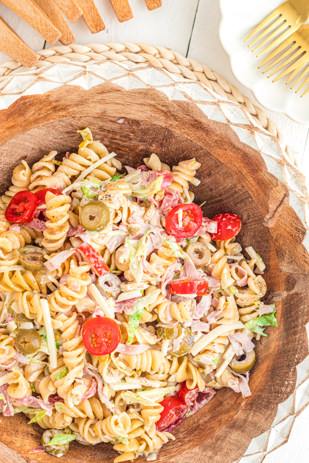 Grinder pasta salad in a wooden bowl with decorative rim.