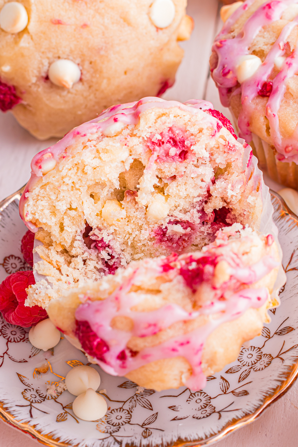 Muffin with raspberries and white chocolate cuts open.