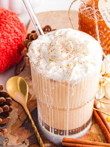 iced pumpkin spice latte topped with whip cream and cinnamon sprinkle.