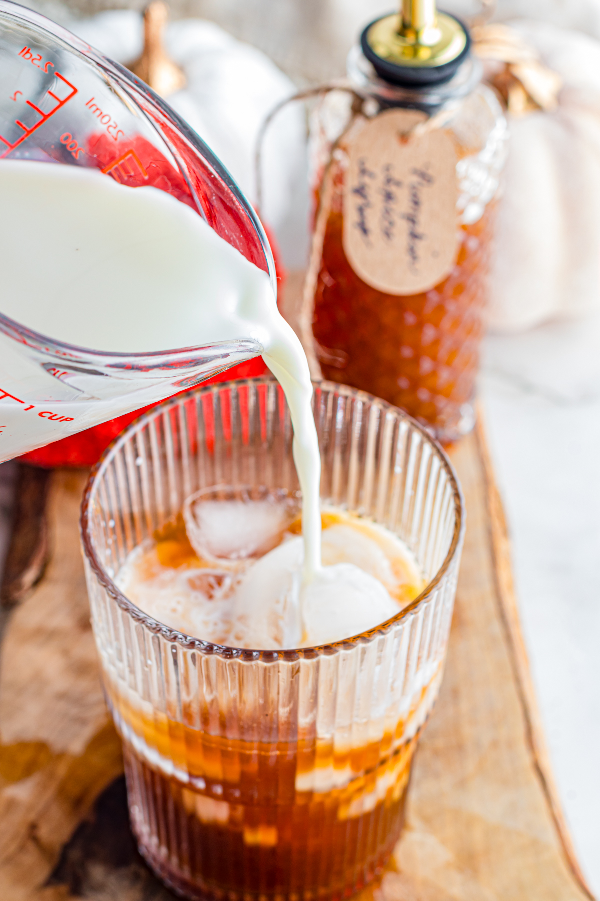 Add milk to an iced coffee.
