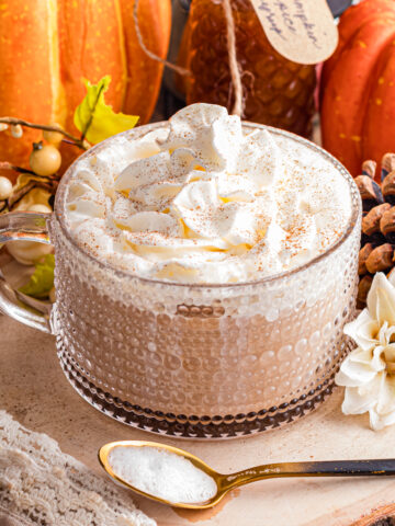 Pumpkin spice latte topped with whipped cream and cinnamon.
