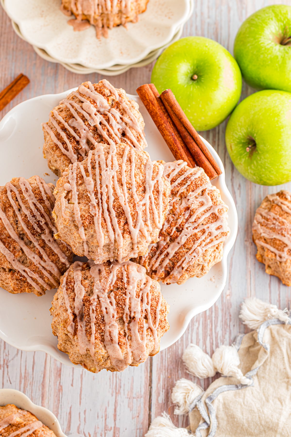 Apple Cinnamon scones on a serving plate, on a table with green apples.