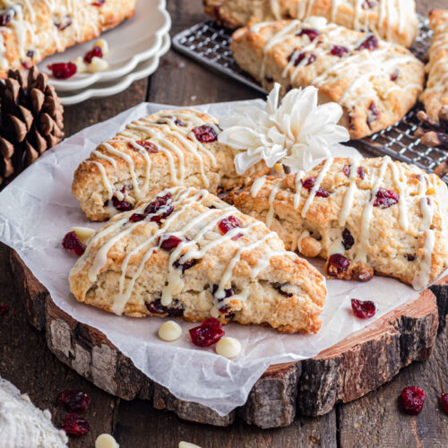 Cranberry white chocolate scones on wood slab.