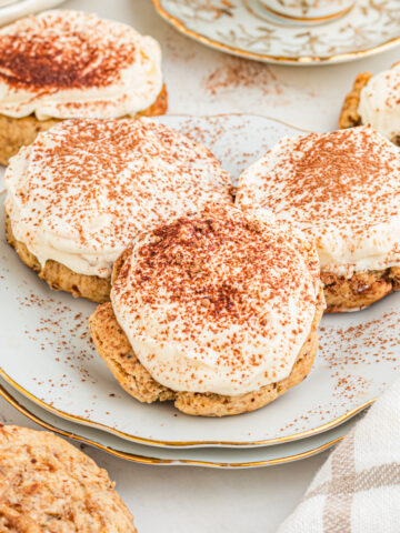 Tiramisu cookies on white plates with gold rims.